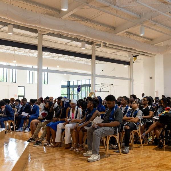 students and their parents at an eighth grade promotion ceremony at Detroit Achievement Academy, seated in chairs